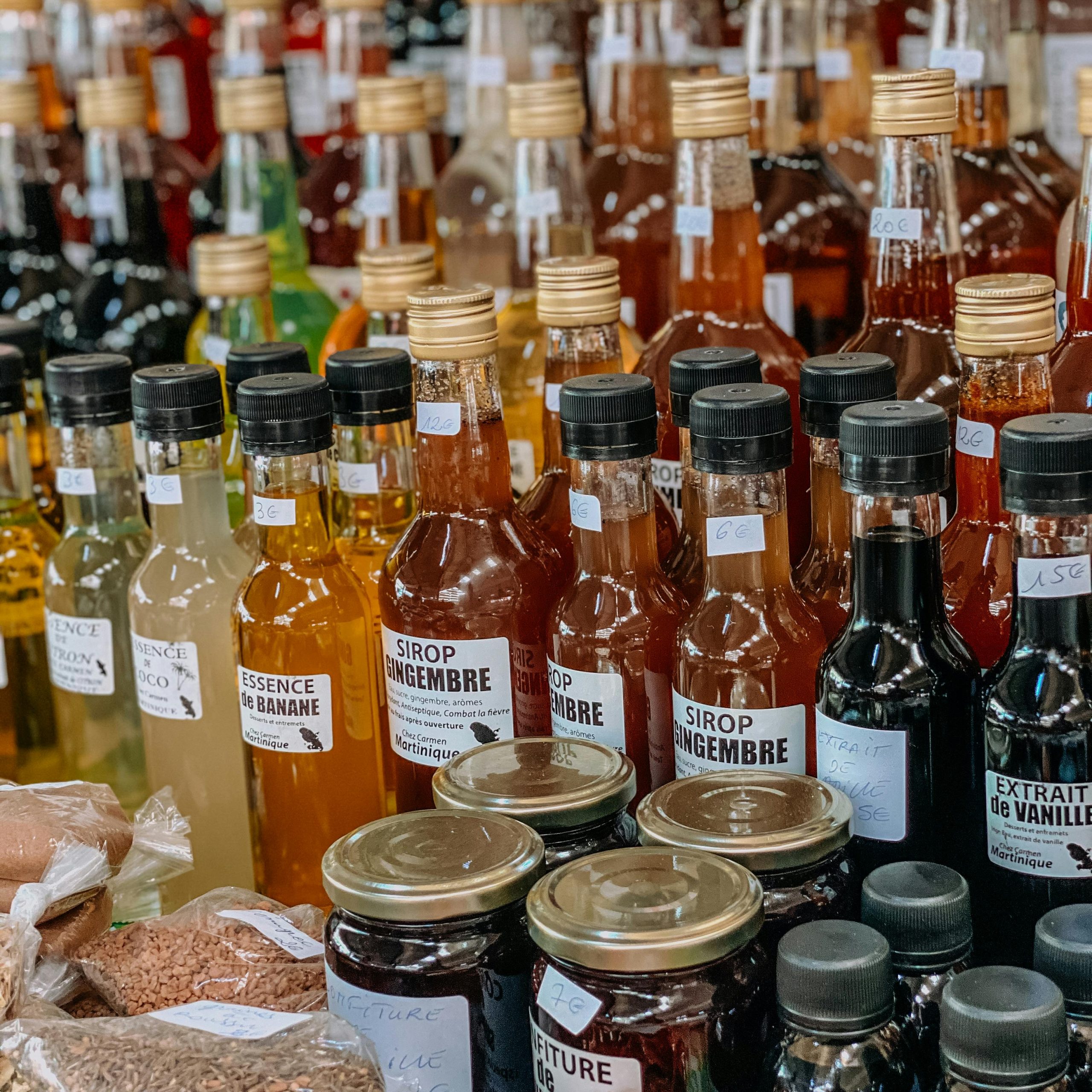 Vibrant assortment of syrups and extracts at a local Martinique market stall.