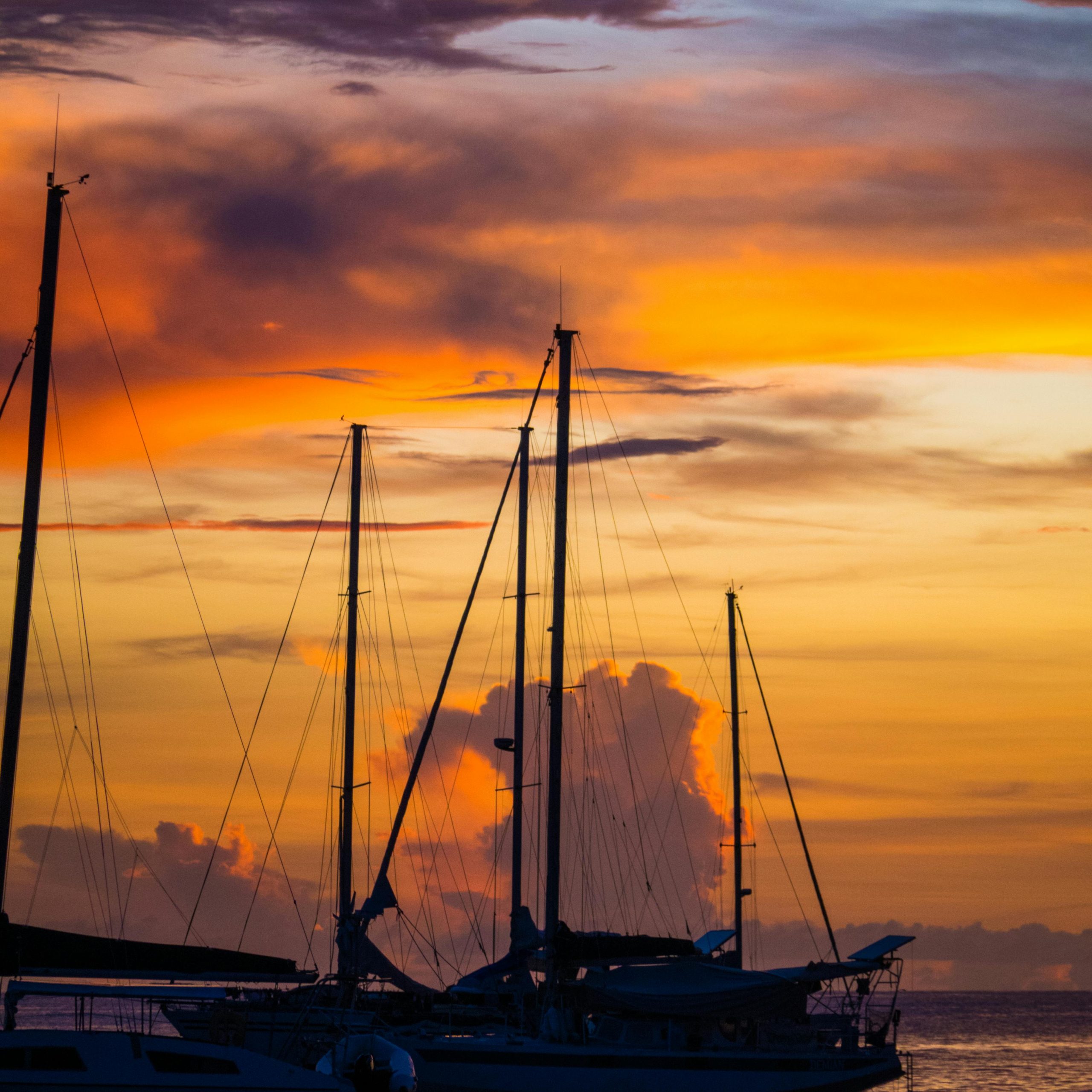Stunning view of boats silhouetted against a vibrant sunset in Baie-Mahault, Guadeloupe.