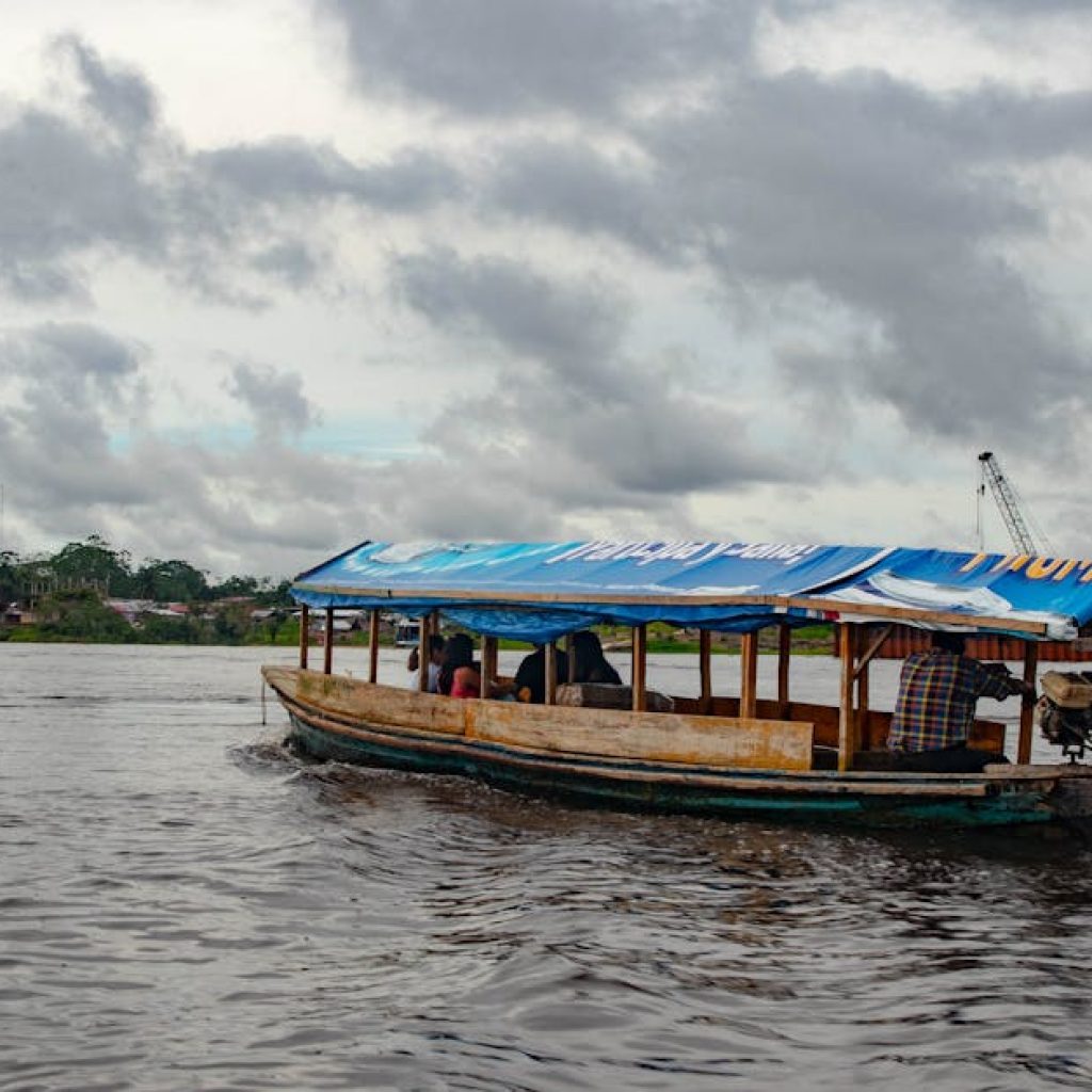 Explore the Amazon River near Iquitos, Peru, with local transportation amidst a cloudy sky.